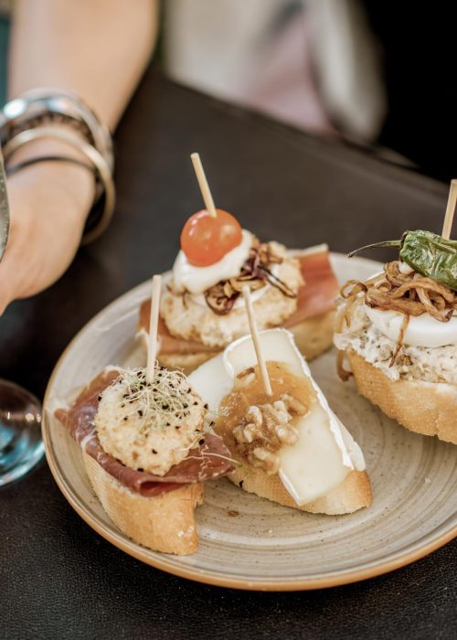 Beautiful and colorful set of pinchos, traditional spanish snack related to tapas, with glass of wine outdoors on the table